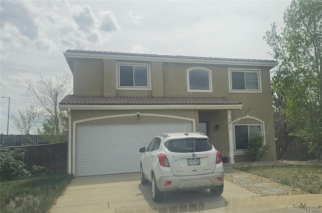 3811 Lisbon Ct, Denver, CO 80249 - view of front of home with concrete driveway, a tile roof, fence, stucco siding, and a garage