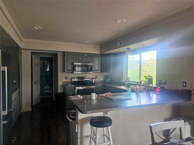 3811 Lisbon Ct, Denver, CO 80249 - kitchen featuring appliances with stainless steel finishes, a peninsula, a breakfast bar, a sink, and recessed lighting