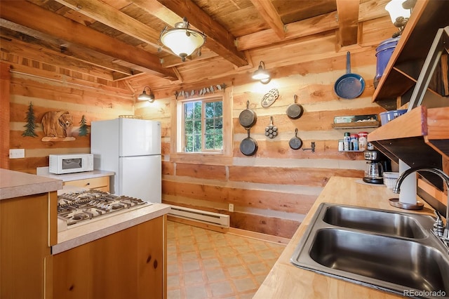 kitchen with wooden walls, baseboard heating, sink, and white appliances