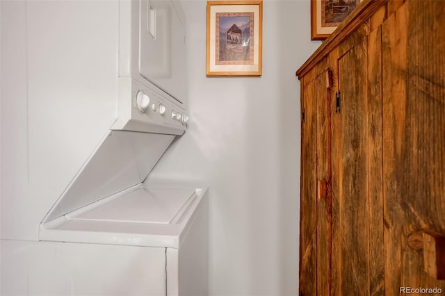 clothes washing area featuring stacked washer / dryer