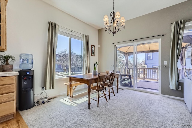 carpeted dining space featuring a chandelier