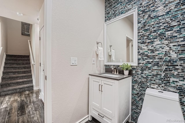 3611 S Perth Cir Unit 103, Aurora, CO 80013 - bathroom with vanity, backsplash, wood finished floors, and a textured wall
