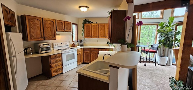 27901 Pine Dr, Evergreen, CO 80439 - kitchen with white appliances, under cabinet range hood, brown cabinetry, and light countertops