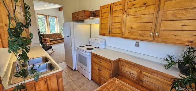 27901 Pine Dr, Evergreen, CO 80439 - kitchen with white electric range oven, brown cabinetry, light countertops, under cabinet range hood, and light tile patterned flooring