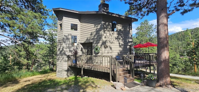 27901 Pine Dr, Evergreen, CO 80439 - view of side of home with a deck and a chimney