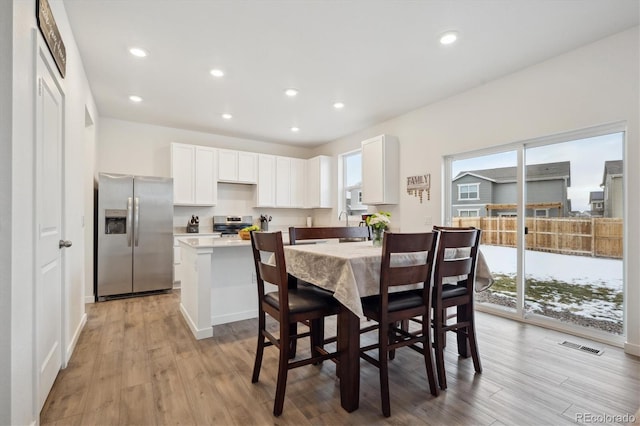 dining space with light hardwood / wood-style flooring