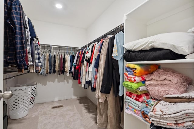 walk in closet featuring light carpet