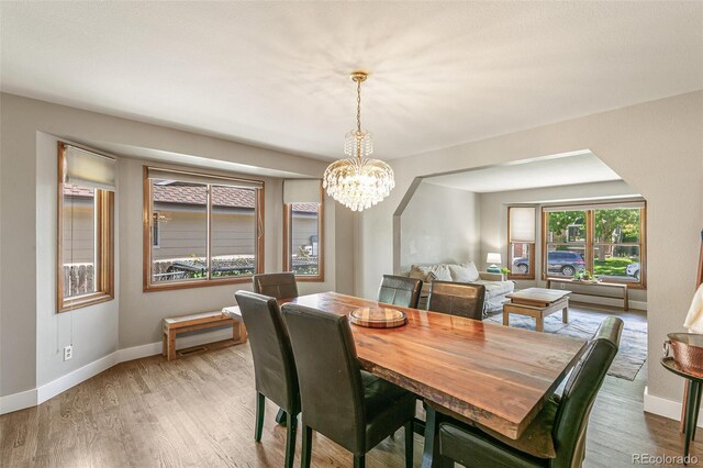 dining space featuring light hardwood / wood-style flooring and a chandelier