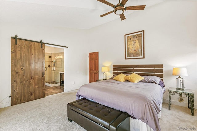 bedroom with light colored carpet, vaulted ceiling, ceiling fan, a barn door, and connected bathroom