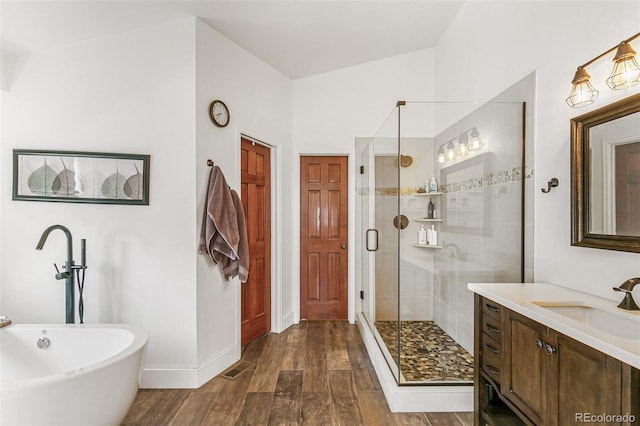 bathroom with hardwood / wood-style floors, vanity, independent shower and bath, and vaulted ceiling