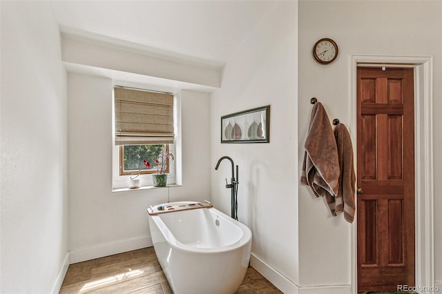 bathroom with hardwood / wood-style flooring and a bathtub