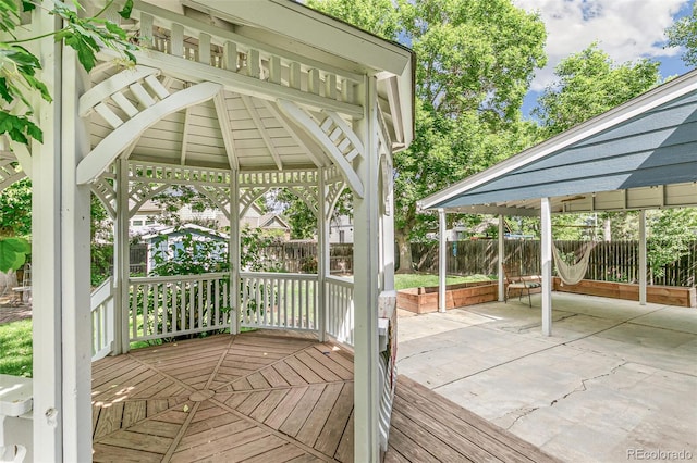 wooden terrace with a gazebo and a patio