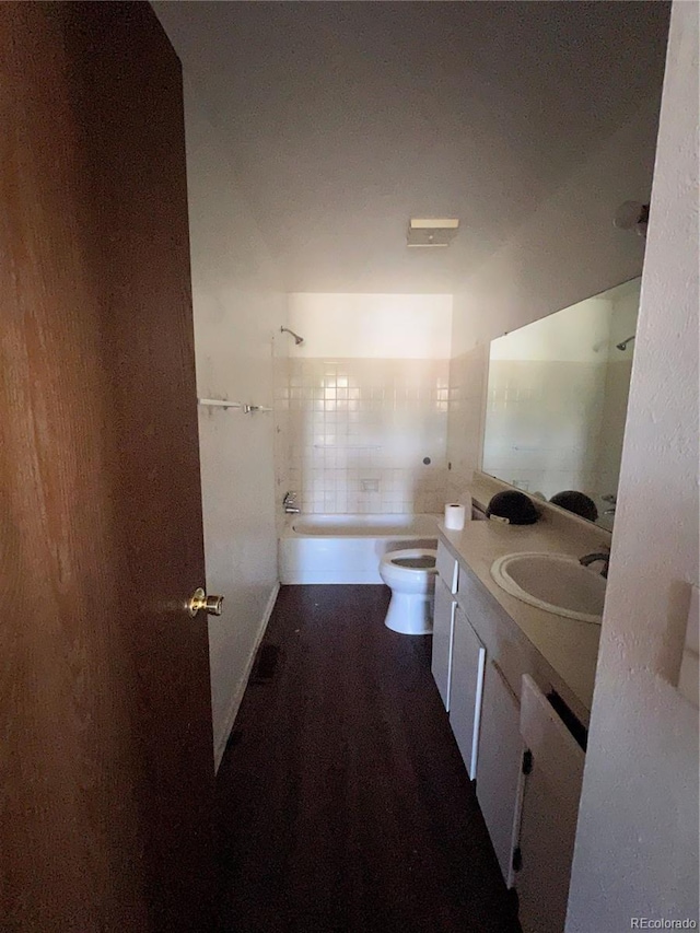 full bathroom featuring vanity, toilet, hardwood / wood-style flooring, and tiled shower / bath