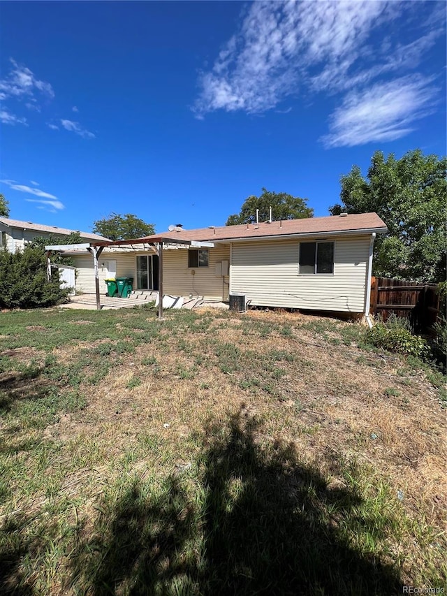 rear view of property featuring a patio area and a lawn