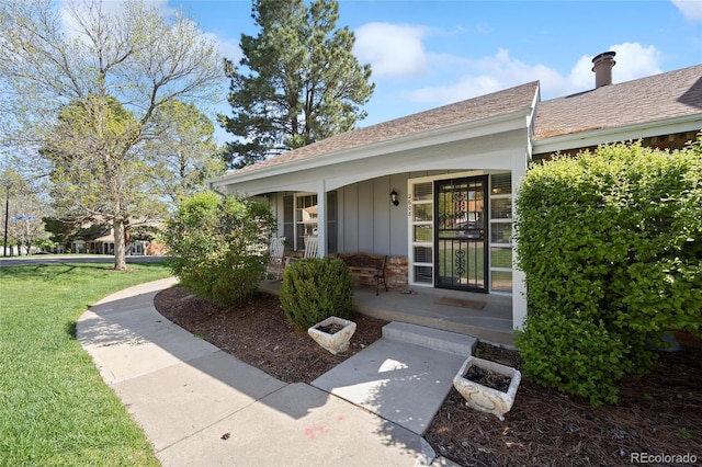 2608 E Fremont Pl, Centennial, CO 80122 - view of exterior entry with board and batten siding, covered porch, and a yard