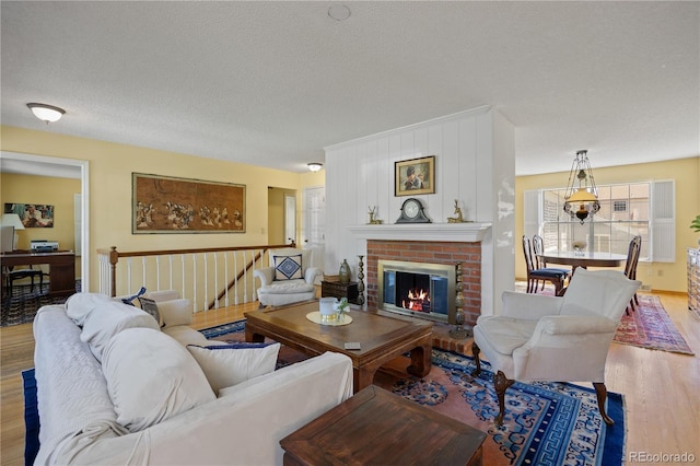 2608 E Fremont Pl, Centennial, CO 80122 - living room featuring wood finished floors, a textured ceiling, and a brick fireplace