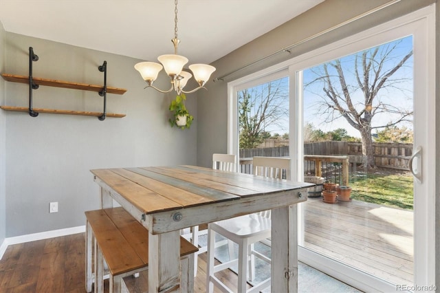 dining space featuring hardwood / wood-style floors and a chandelier