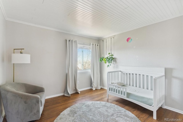 bedroom featuring dark hardwood / wood-style floors, ornamental molding, and a nursery area