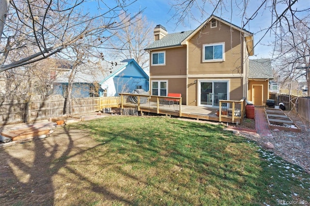 back of house featuring a lawn and a wooden deck