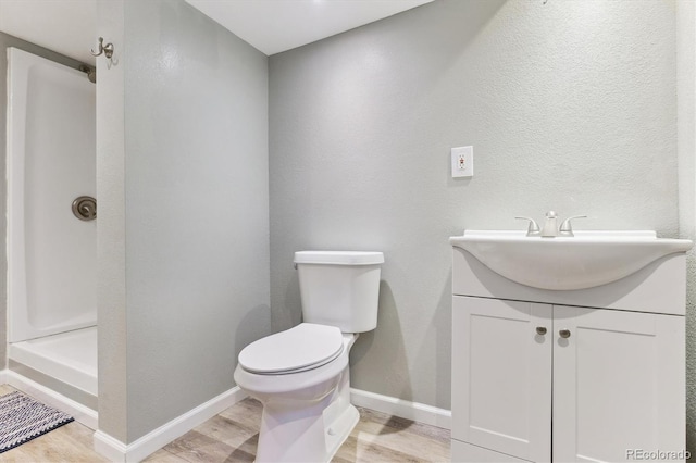 bathroom with vanity, toilet, and wood-type flooring