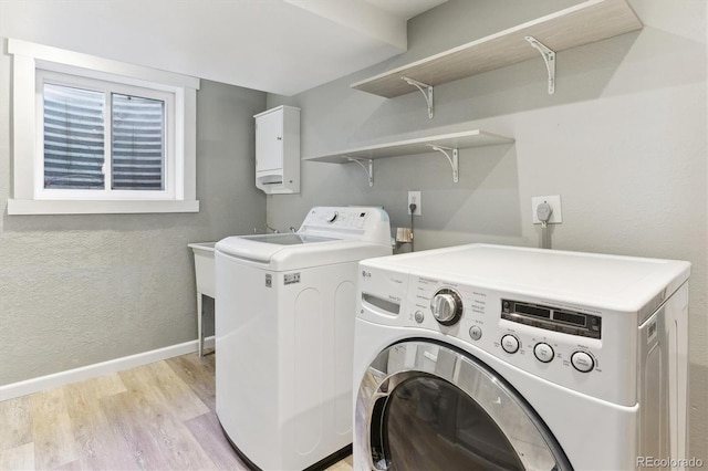 laundry room with light hardwood / wood-style flooring and washing machine and clothes dryer