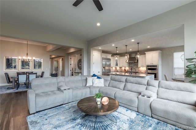 living area with a chandelier, dark wood-type flooring, ceiling fan, and recessed lighting