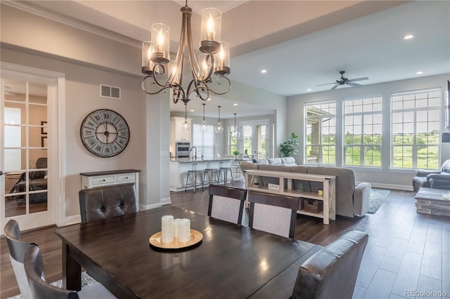 dining area with ceiling fan, dark wood finished floors, baseboards, recessed lighting, and a chandelier