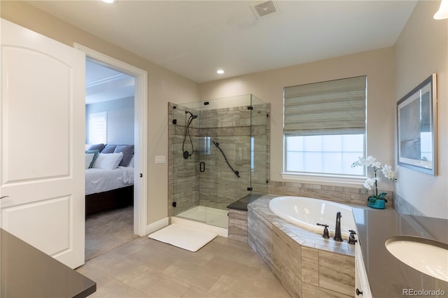 bathroom featuring a garden tub, a sink, healthy amount of natural light, a stall shower, and recessed lighting