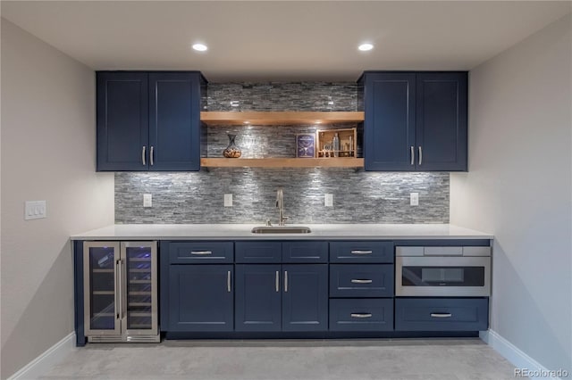 indoor wet bar featuring beverage cooler, baseboards, decorative backsplash, stainless steel oven, and recessed lighting