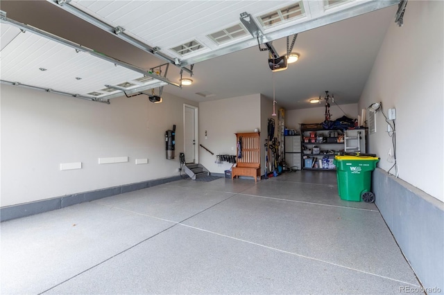 garage with a central vacuum unit, a garage door opener, and freestanding refrigerator