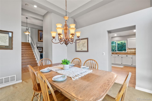 dining space with an inviting chandelier, light colored carpet, visible vents, recessed lighting, and stairs