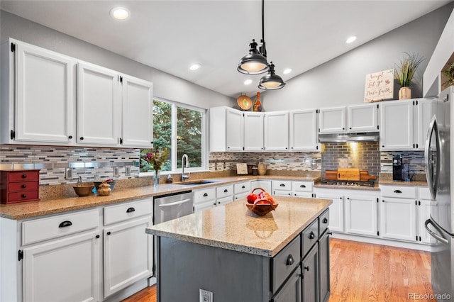 kitchen with white cabinets, under cabinet range hood, a sink, and appliances with stainless steel finishes