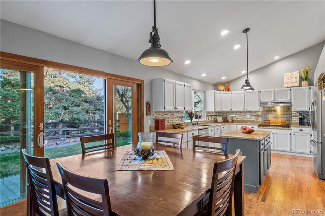dining room featuring light wood-style flooring, lofted ceiling, and recessed lighting
