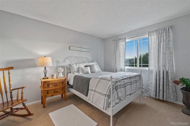 carpeted bedroom featuring a textured ceiling and baseboards
