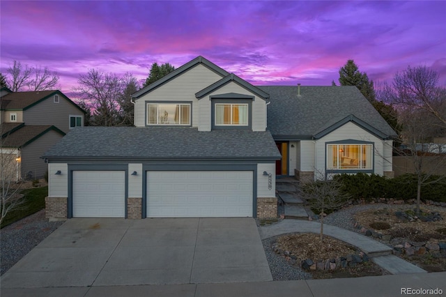 view of front of property featuring roof with shingles, concrete driveway, and a garage