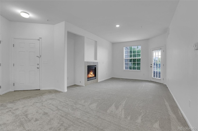 unfurnished living room with light carpet and a fireplace