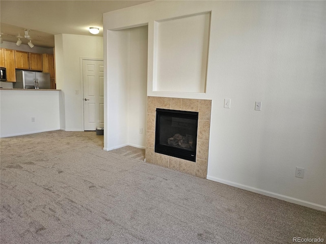 unfurnished living room featuring light colored carpet and a fireplace