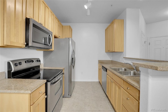 kitchen featuring stainless steel appliances, light brown cabinets, light tile patterned floors, and sink