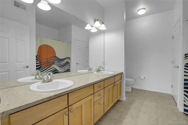 bathroom with tile patterned flooring, vanity, and toilet