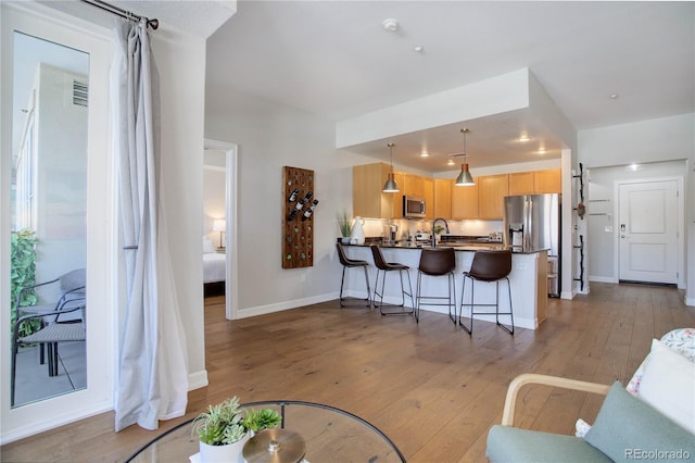 living area featuring light wood-type flooring, baseboards, and visible vents