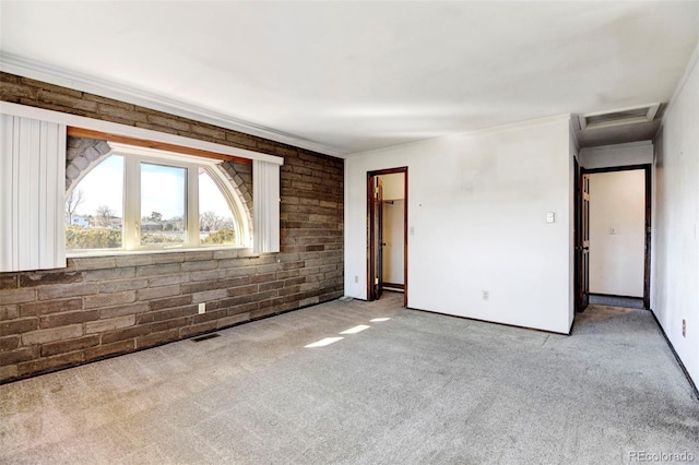 unfurnished room featuring brick wall and light carpet