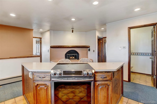 kitchen featuring crown molding, stainless steel electric range oven, a kitchen island, a baseboard radiator, and light colored carpet