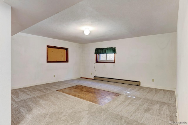 unfurnished room featuring baseboard heating, carpet, and a textured ceiling