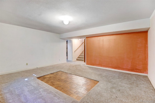 basement featuring a textured ceiling and carpet flooring