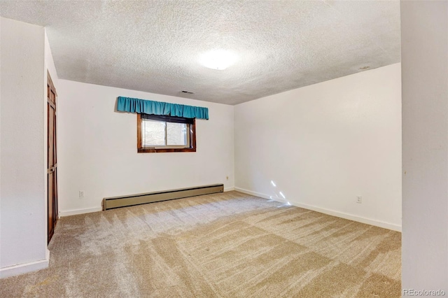 carpeted empty room featuring a baseboard radiator and a textured ceiling