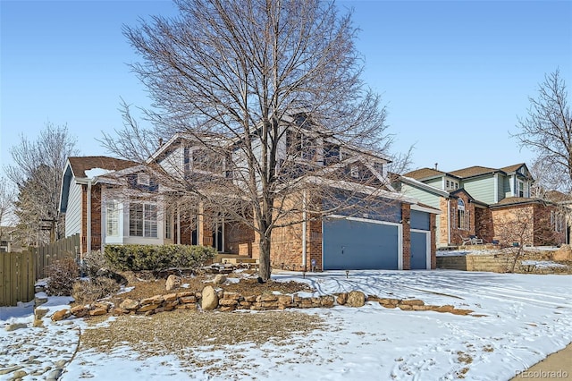 traditional-style house with a garage, fence, and brick siding