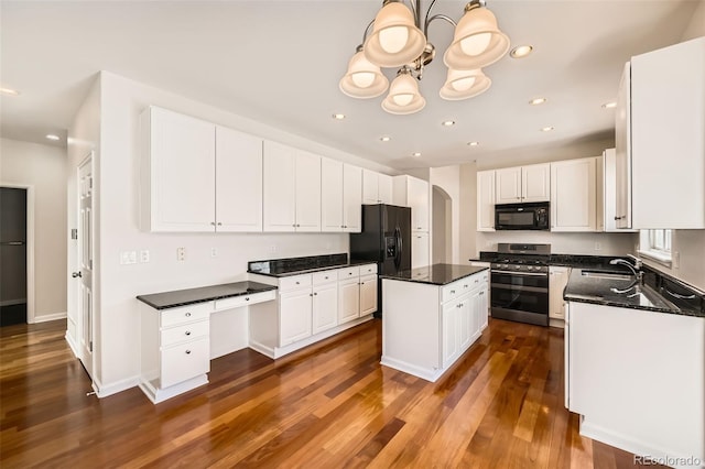 kitchen featuring arched walkways, dark wood finished floors, black appliances, white cabinetry, and a sink