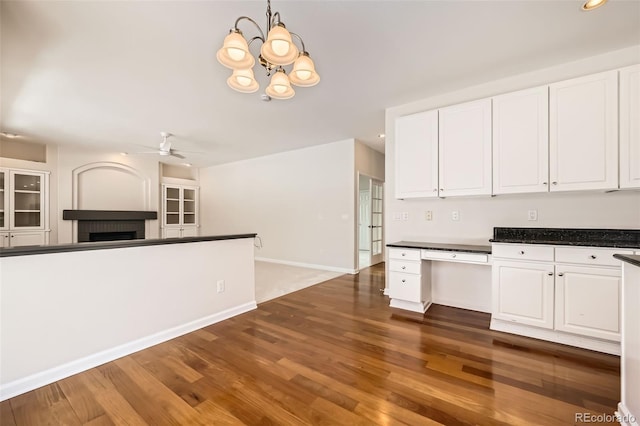 kitchen featuring dark wood-type flooring, dark countertops, and white cabinetry