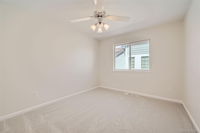 empty room with baseboards, a ceiling fan, visible vents, and light colored carpet