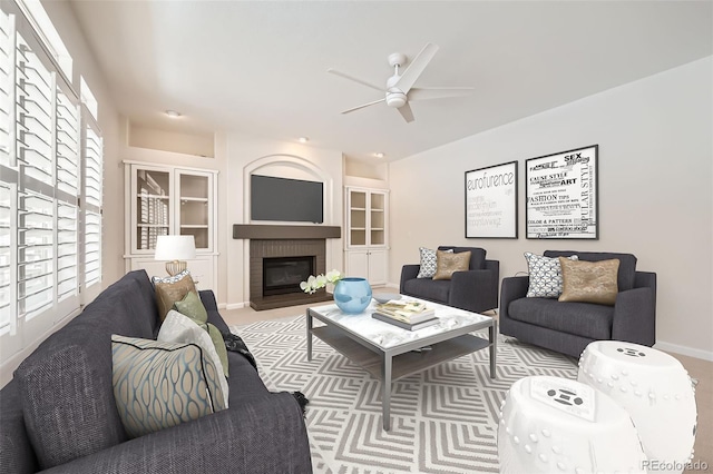 living room featuring built in features, a brick fireplace, ceiling fan, and baseboards